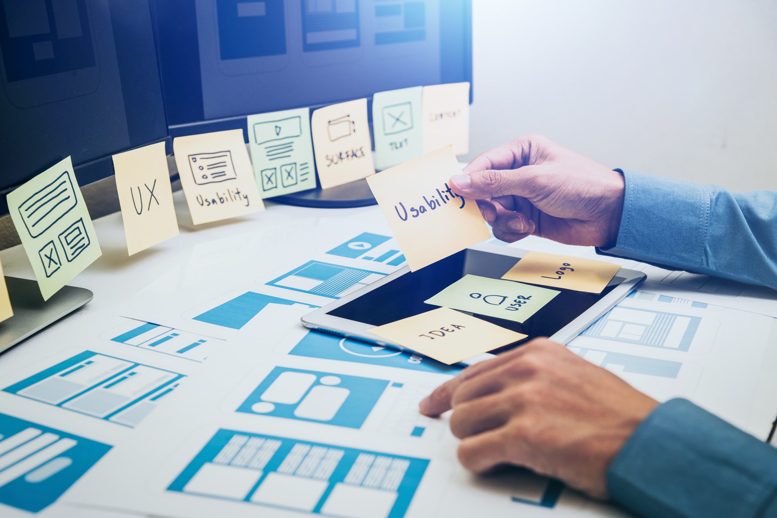 web designer at laptop with sticky notes